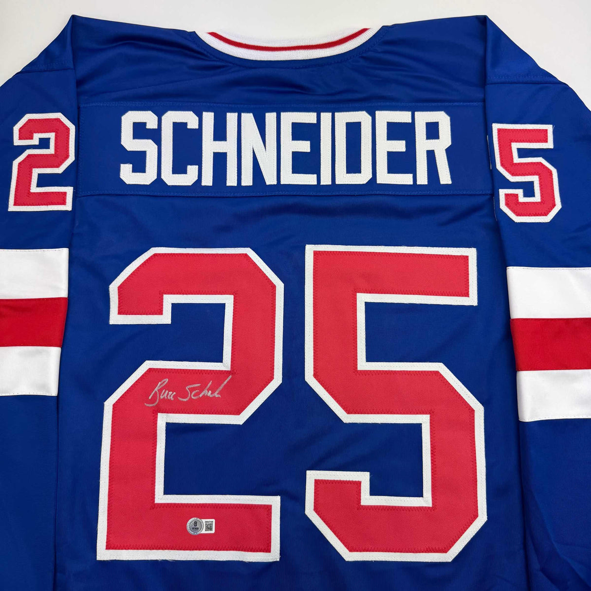 Camiseta de hockey azul autografiada/firmada de Buzz Schneider del equipo estadounidense Miracle On Ice de los Juegos Olímpicos de 1980, Beckett BAS COA