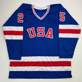 Camiseta de hockey azul autografiada/firmada de Buzz Schneider del equipo estadounidense Miracle On Ice de los Juegos Olímpicos de 1980, Beckett BAS COA
