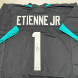 Camiseta de fútbol americano autografiada/firmada de Travis Etienne Jr. Jacksonville, color negro, Beckett BAS COA