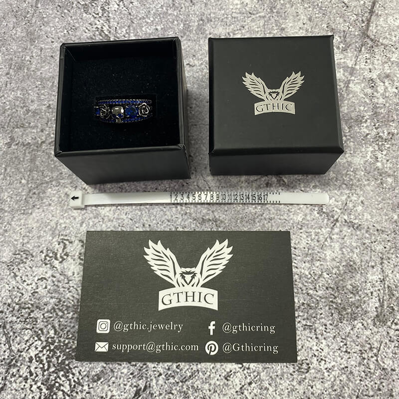 Anillo de latón con incrustaciones de circonita y calavera con flor negra