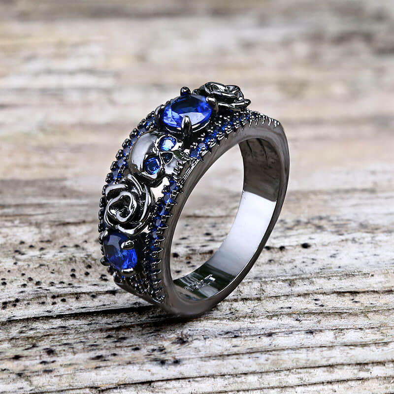 Anillo de latón con incrustaciones de circonita y calavera con flor negra