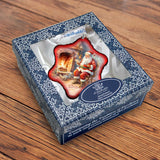 Adorno de copo de nieve de vidrio de Papá Noel junto a la chimenea de G. Debrekht - Decoración navideña de Papá Noel y muñeco de nieve - 754-047